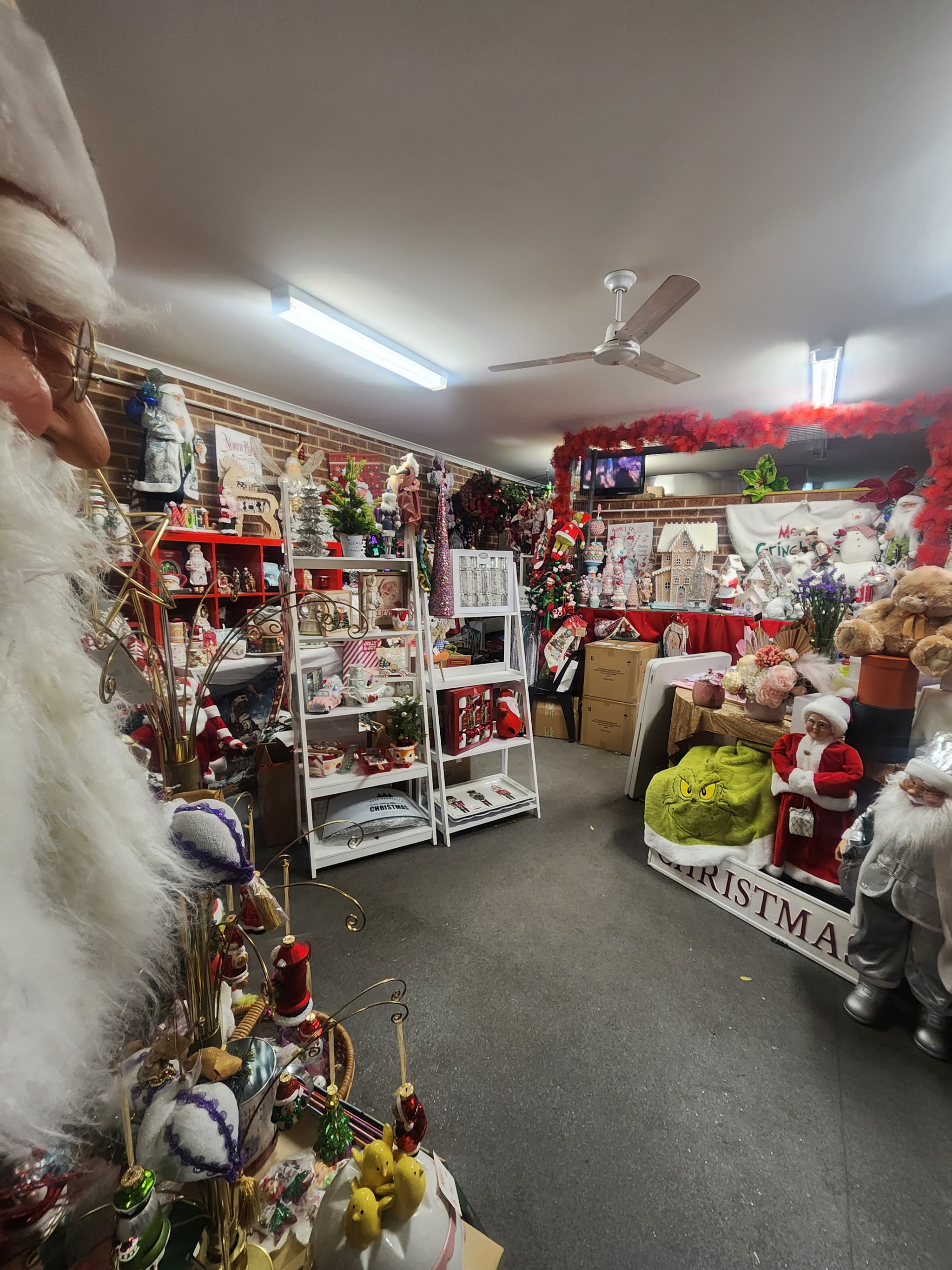 A wide view of the shop floor with white shelving, Christmas decorations and red tinsel