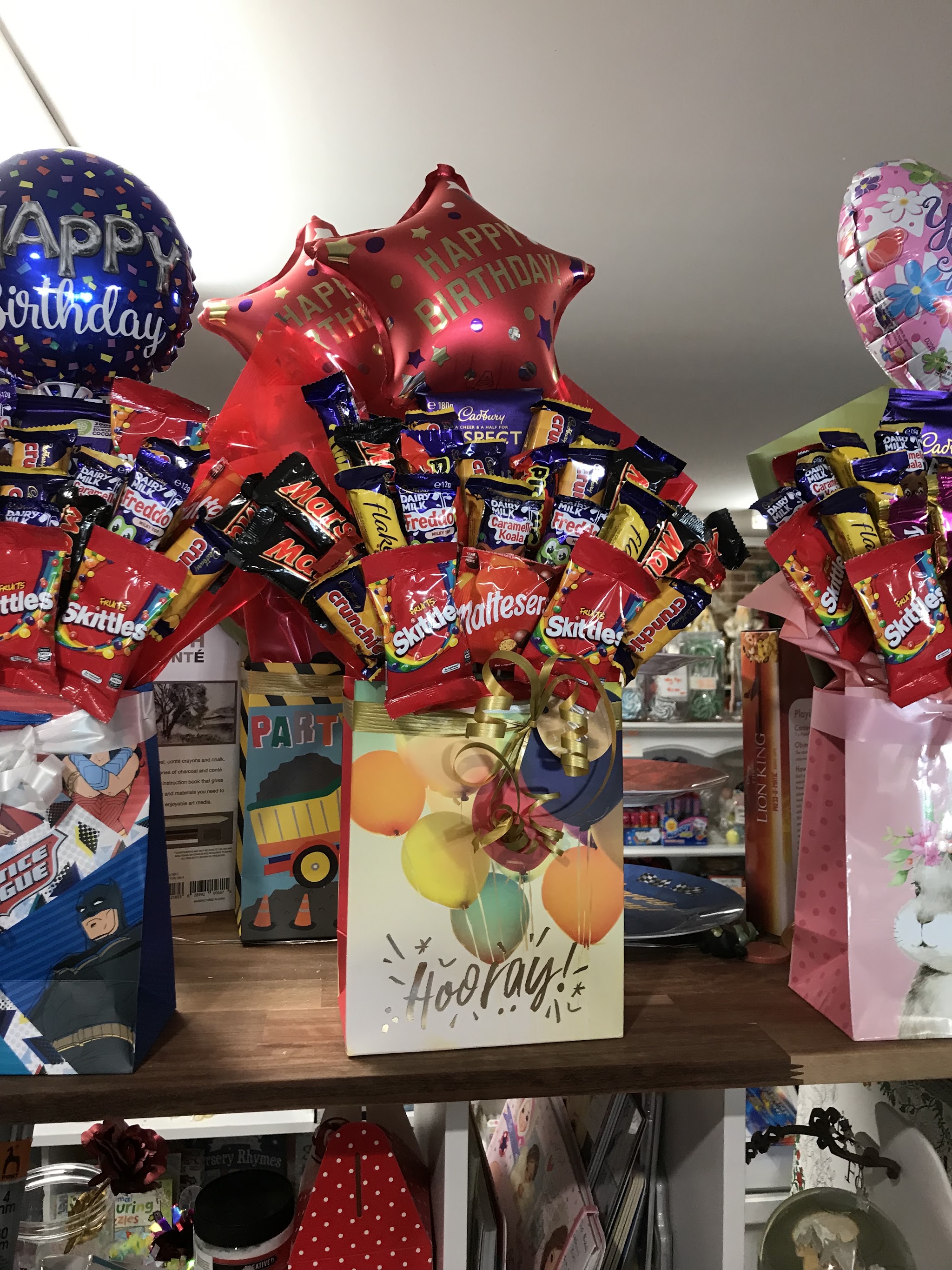 Lolly bouquets with red Happy Birthday star balloons in Hooray gift bags