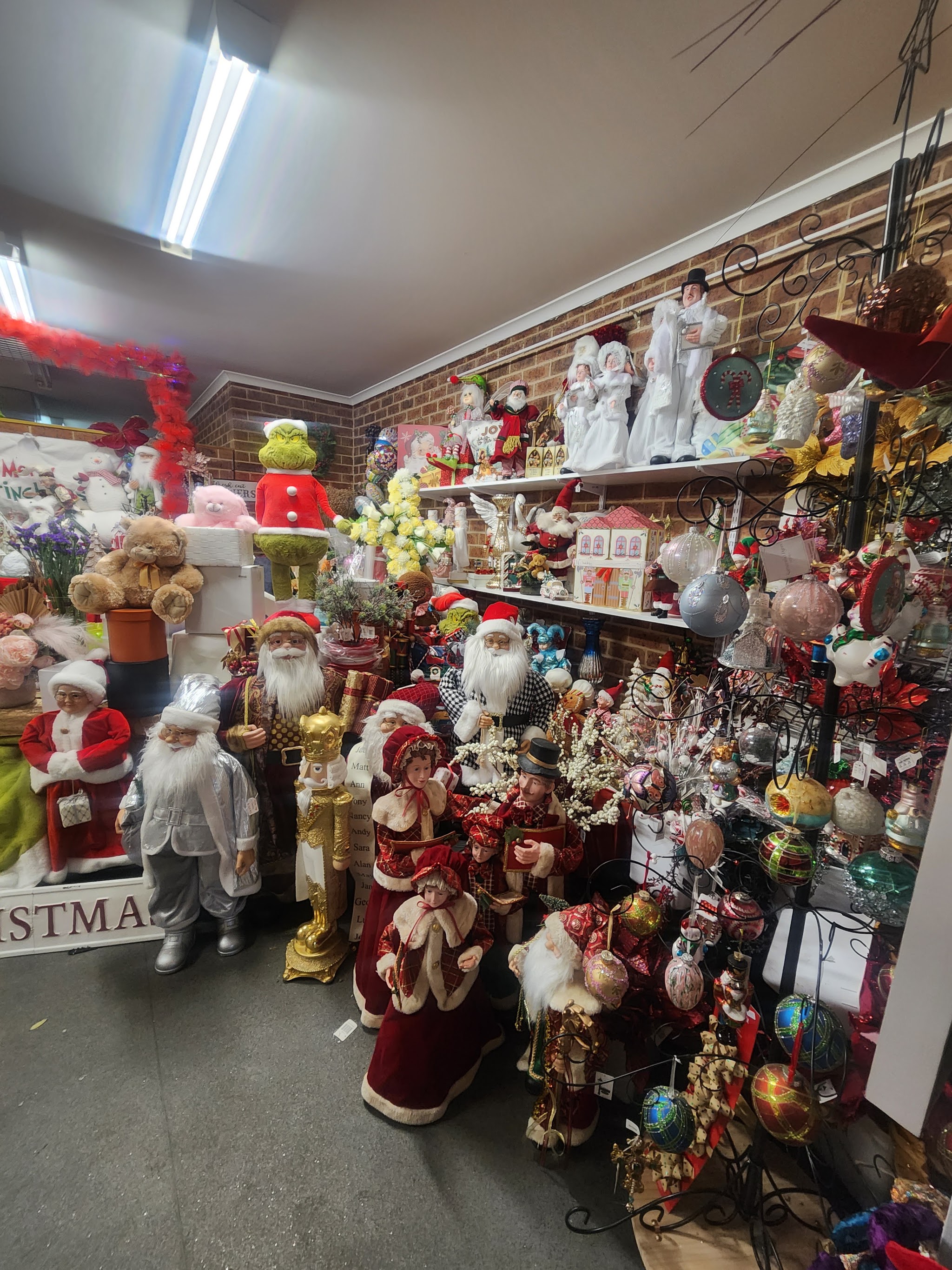 Shelves crowded with Santa figurines, nutcrackers, a Grinch and hanging Christmas ornaments